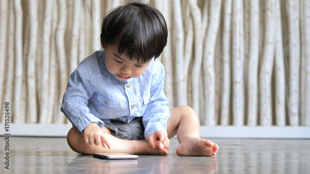 Asian little boy touch on the screen of cellphone Asian little boy touch on the screen of cellphone