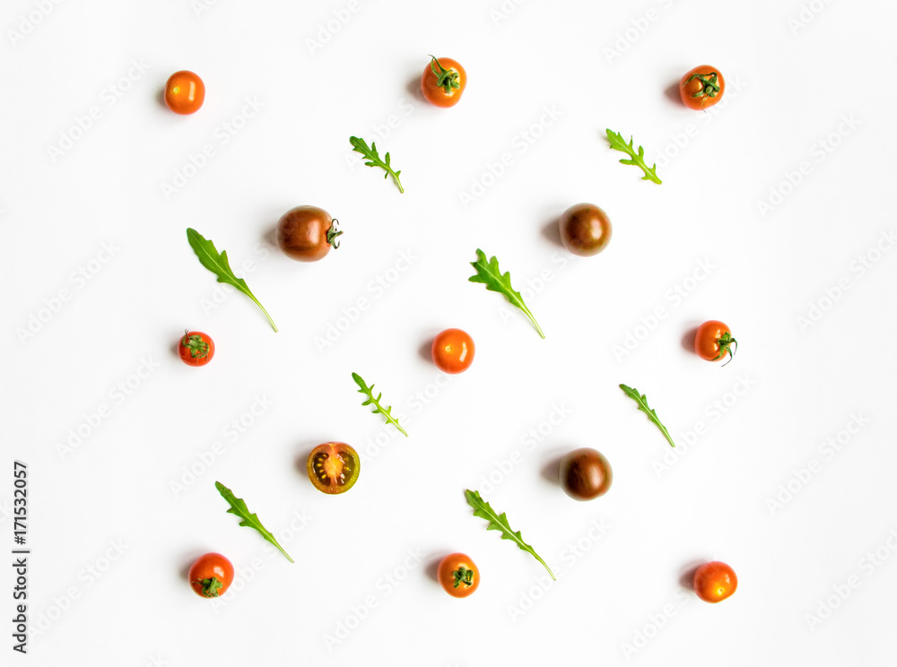 Cherry tomatoes and rocket salad leaves pattern on white background. Flat lay Cherry tomatoes and rocket salad leaves pattern on white background. Flat lay