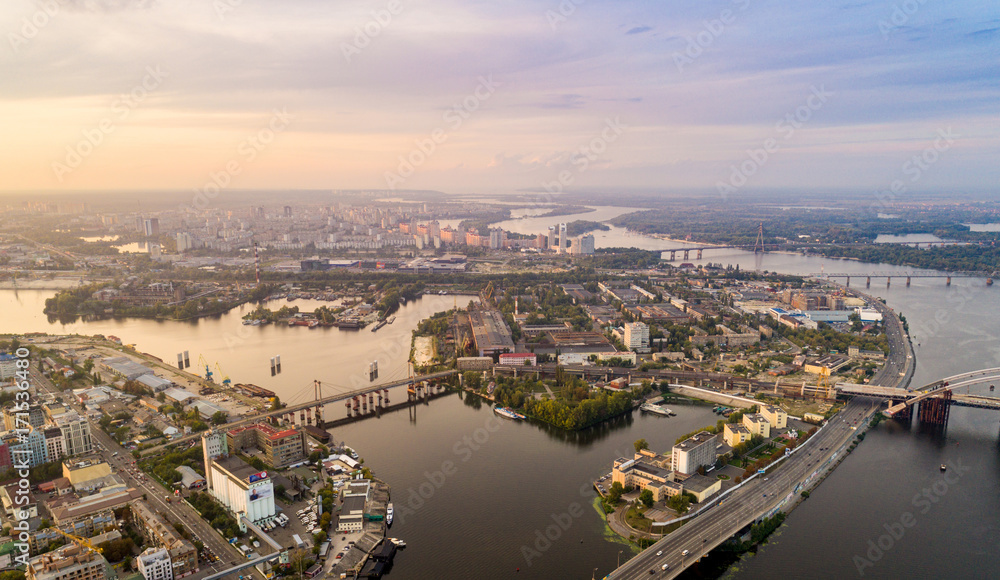 Obraz premium Panoramic aerial view of the old part of the city - Podol district. View of the Rybalsky Island at sunset.