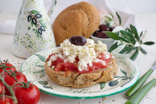 Εκτύπωση καμβά Dakos traditional greek appetizer on a traditional plate with ceramic olive oil jar, dry rye bread, olives and olive branch