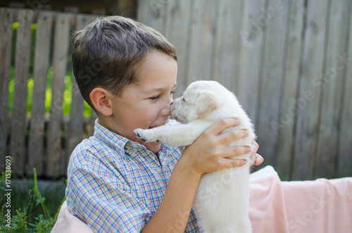 Little boy with cut Labrador puppy on his hands. Lovly friens - 8 years old man amd pet
