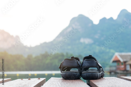 couple hiking sandals on mountain near river on nature background. Trekking shoes of family, man and woman. Travel healthy active lifestyle. Outdoor freedom.
