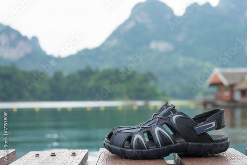 couple hiking sandals on mountain near river on nature background. Trekking shoes of family, man and woman. Travel healthy active lifestyle. Outdoor freedom. Feet selfie.