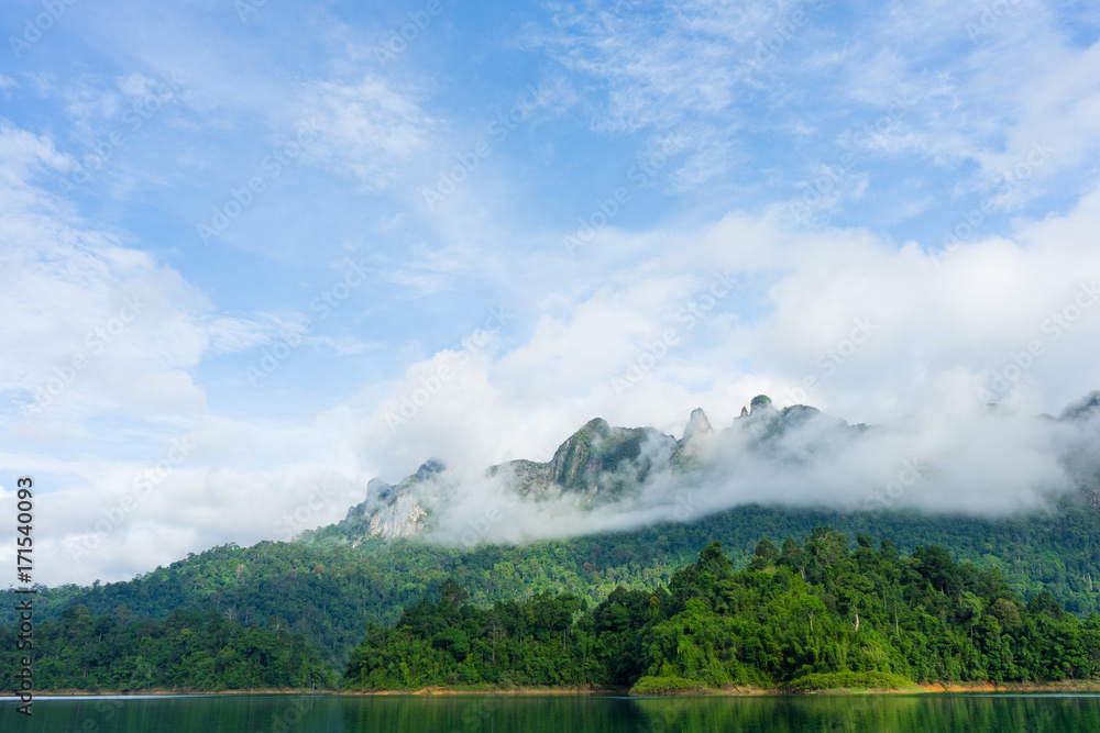 Obraz premium Mountains and lake in mist with blue sky