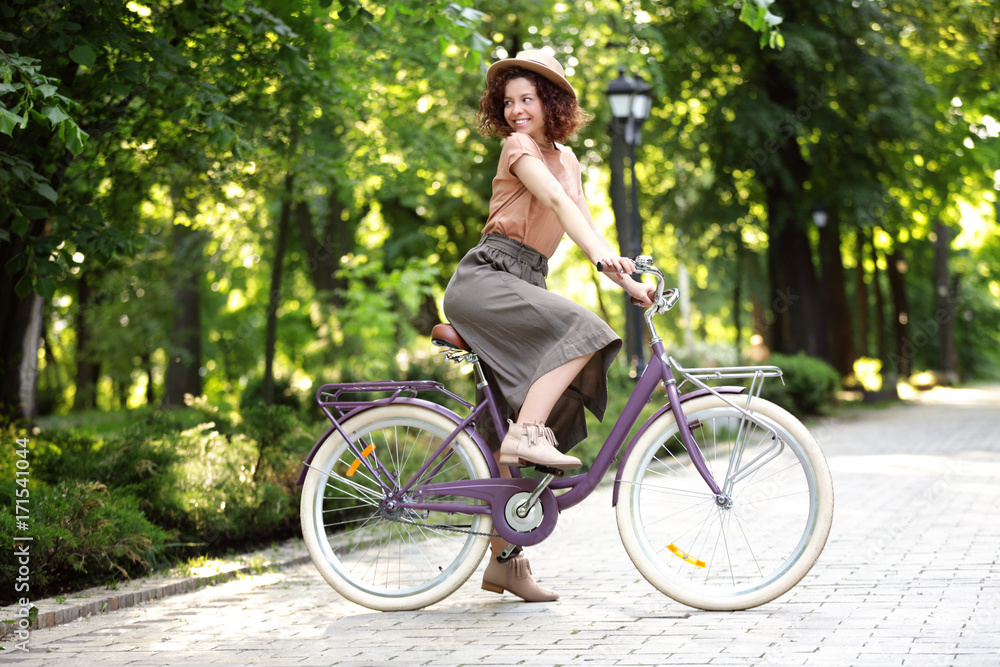 Obraz premium Beautiful young woman with bicycle, outdoors