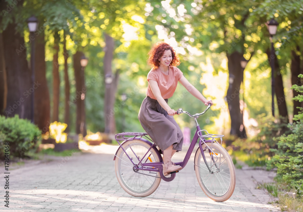 Beautiful young woman with bicycle, outdoors
