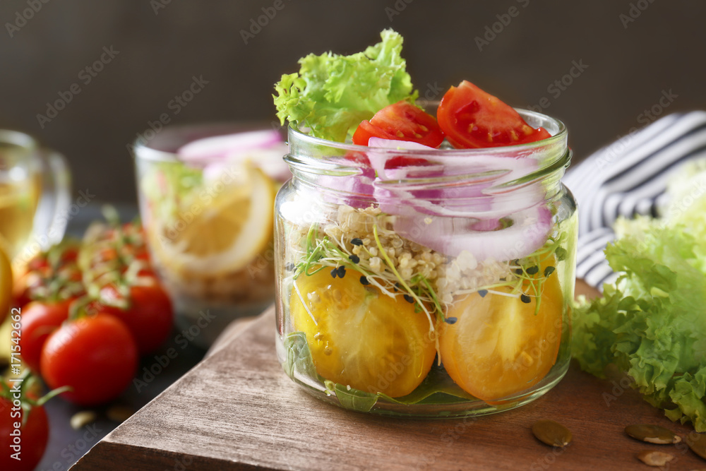 Vegetable salad with quinoa served in glass jar on kitchen table Vegetable salad with quinoa served in glass jar on kitchen table