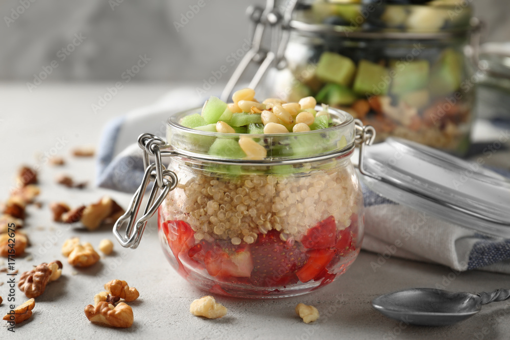 Fruit salad with quinoa served in glass jar on kitchen table Fruit salad with quinoa served in glass jar on kitchen table