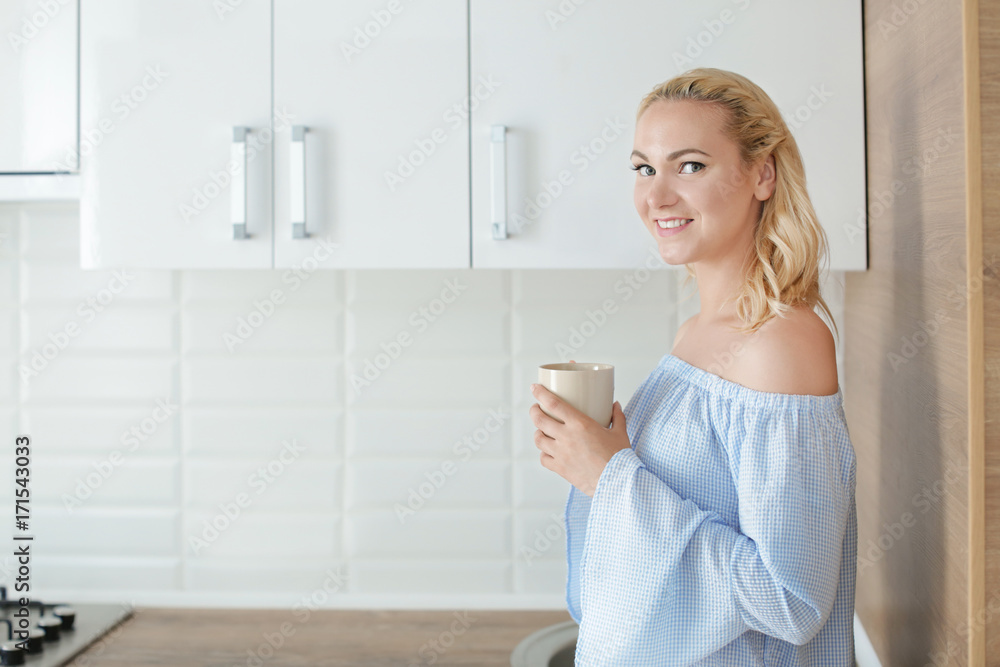 Beautiful woman drinking coffee in kitchen at home Beautiful woman drinking coffee in kitchen at home