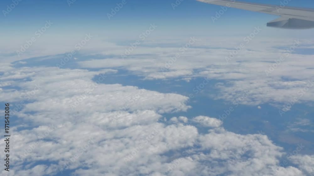 Beautiful view of the blue sky with clouds from the porthole of the plane during the flight Beautiful view of the blue sky with clouds from the porthole of the plane during the flight