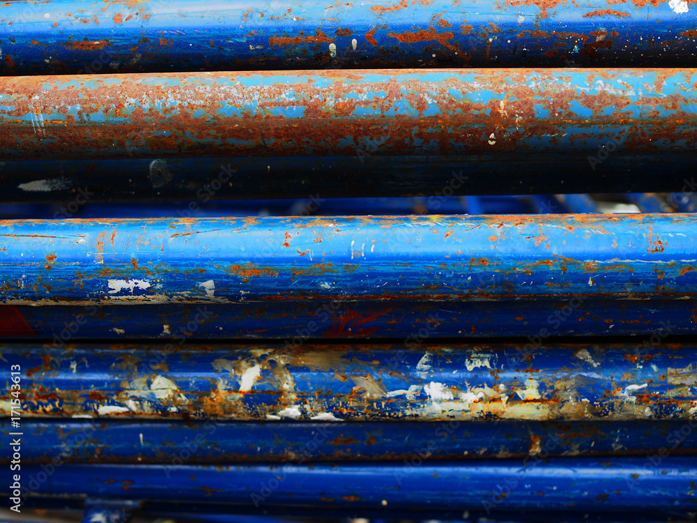 Old rusty dirty damaged peeled off blue painted iron steel construction rod stacking horizontally, close up shot Old rusty dirty damaged peeled off blue painted iron steel construction rod stacking horizontally, close up shot