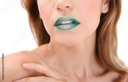 Young woman with bright green makeup on white background, closeup