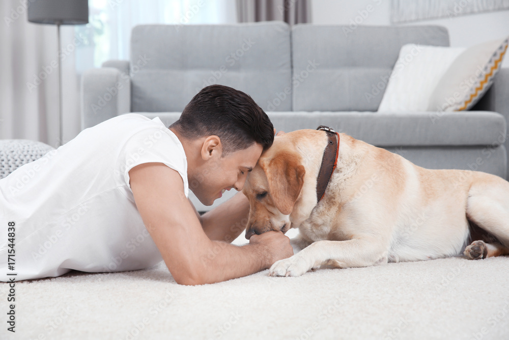 Young man resting with yellow retriever at home Young man resting with yellow retriever at home