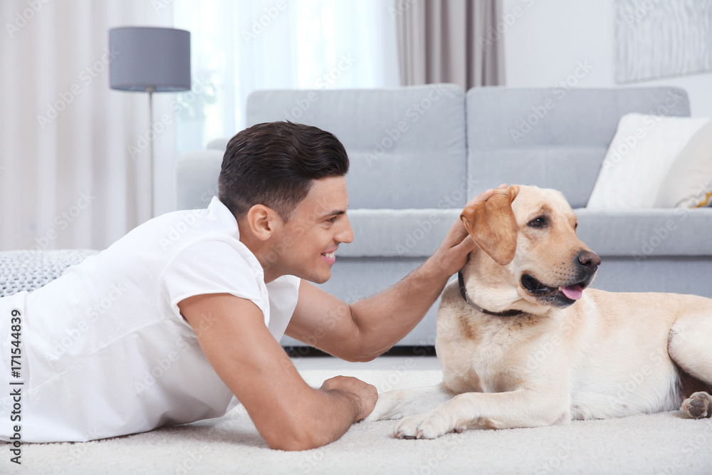 Young man resting with yellow retriever at home Young man resting with yellow retriever at home