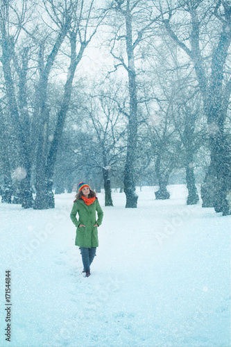 Young woman enjoys the walk in a snow in nature. Winter concept