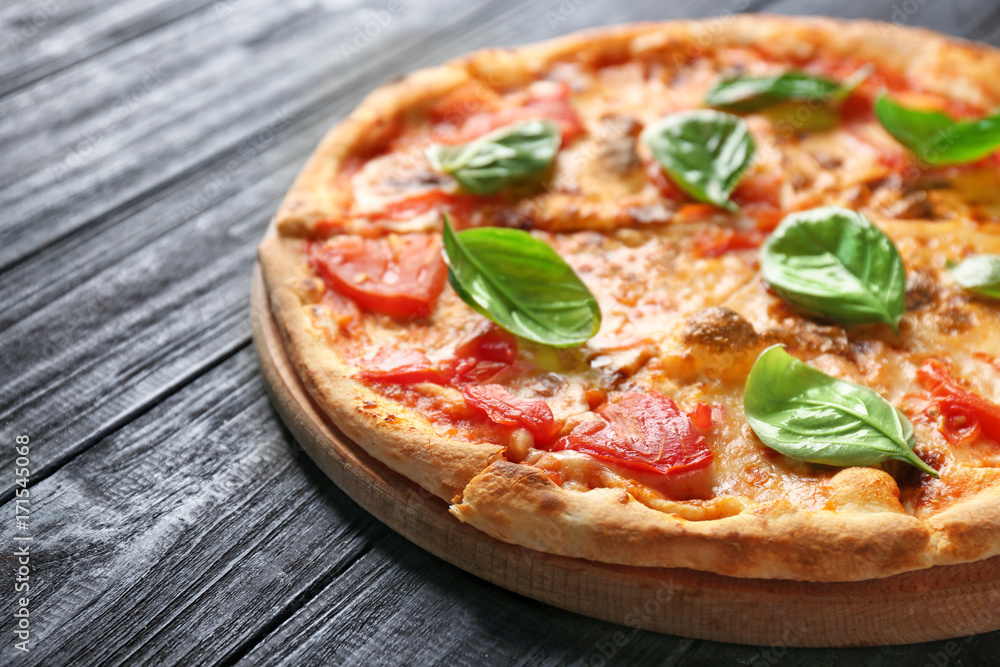 Delicious pizza with tomatoes and fresh basil on wooden background