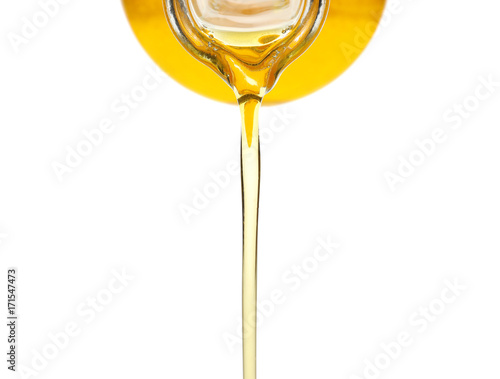 Pouring cooking oil from pitcher, on white background