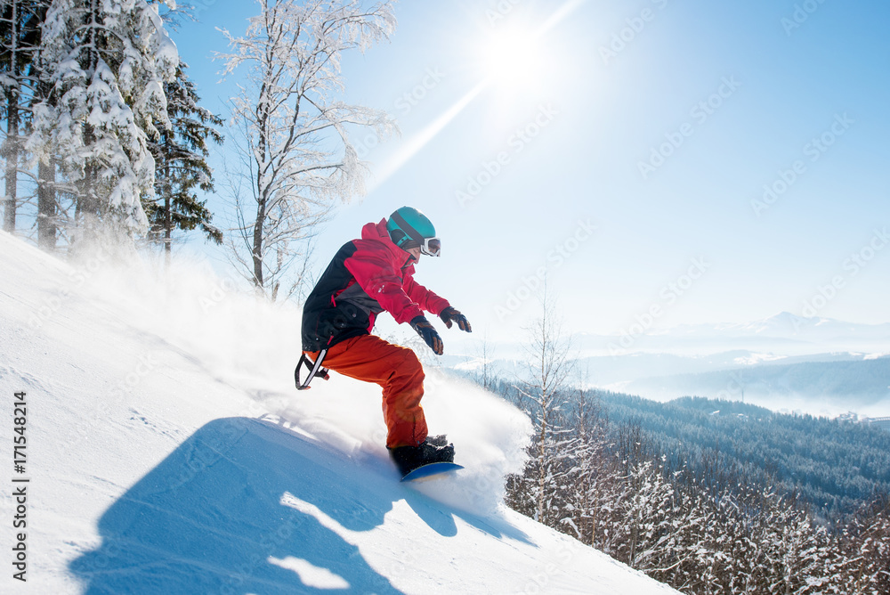 Shot of a freeride snowboarder riding in the mountains wearing snowboarding gear beautiful scenery winter sunny day copyspace