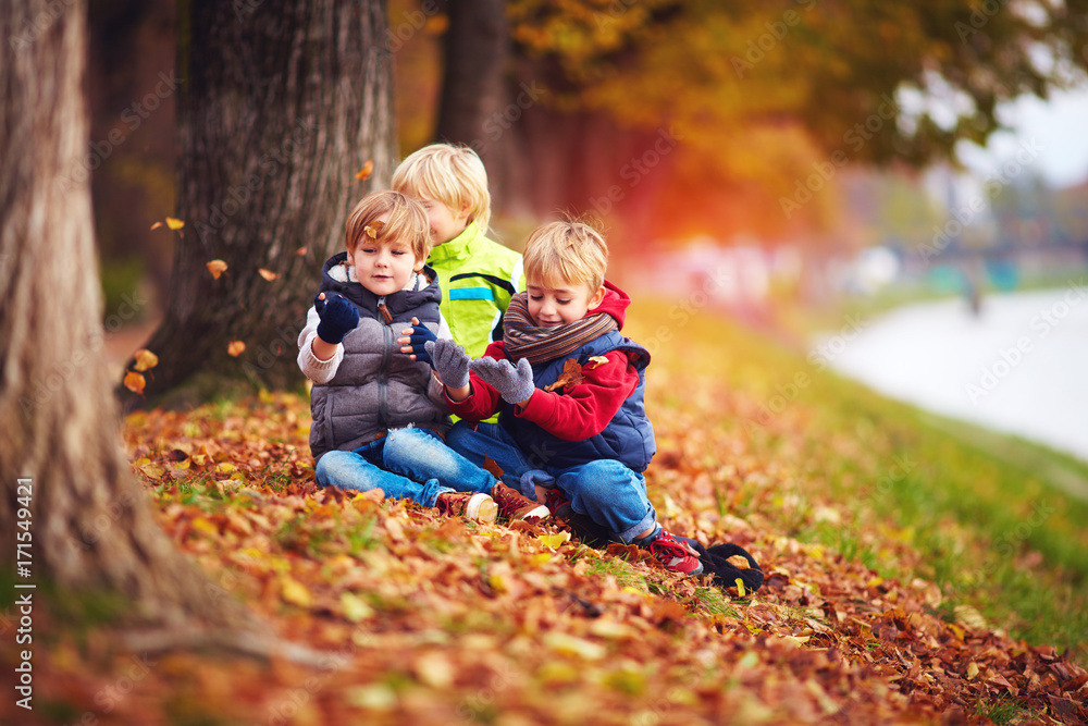 happy kids, friend having fun among fallen leaves in autumn park happy kids, friend having fun among fallen leaves in autumn park
