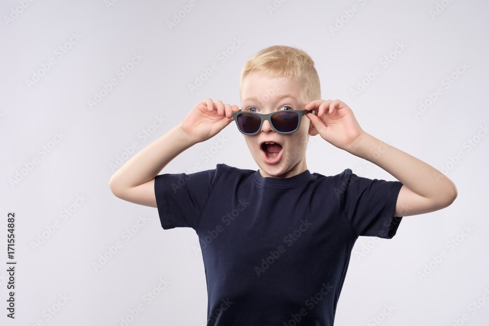 Portrait of a little caucasian boy with blond hair wearing sunglasses. Portrait of a little caucasian boy with blond hair wearing sunglasses.