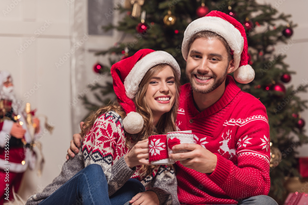 couple with cups at christmastime couple with cups at christmastime