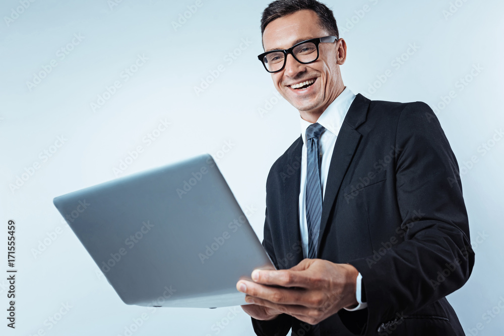 Low angle shot of radiant businessman working on laptop Low angle shot of radiant businessman working on laptop