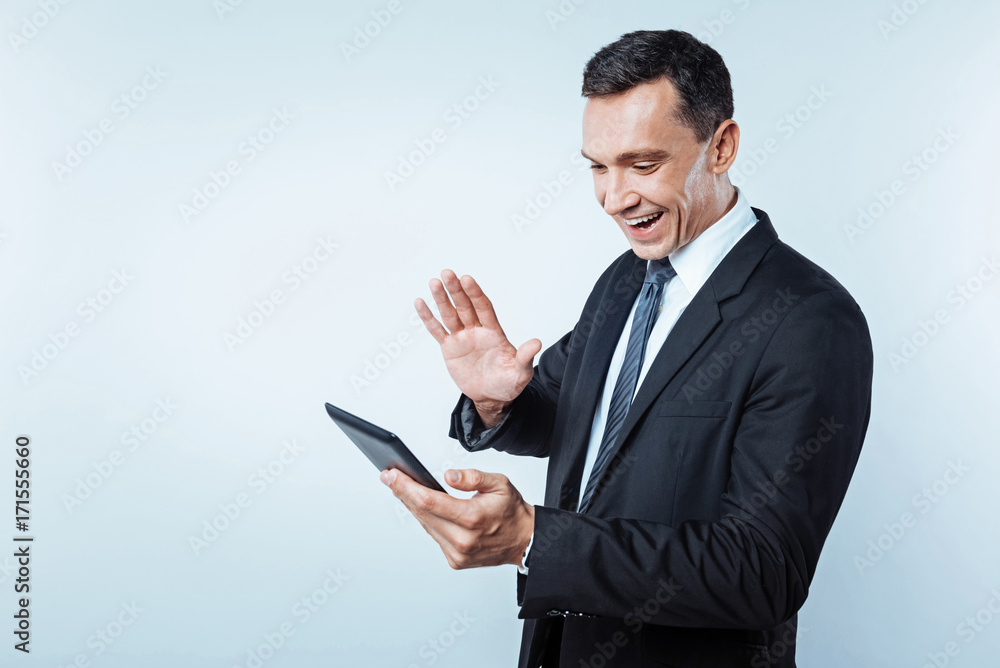 Positive minded gentleman having video call on digital tablet Positive minded gentleman having video call on digital tablet