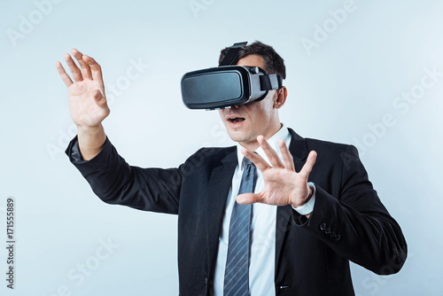 Businessman gesturing while wearing visual reality goggles