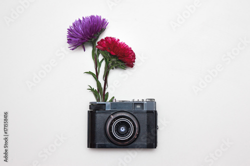 Creative photo of old vintage camera with peony flower photo