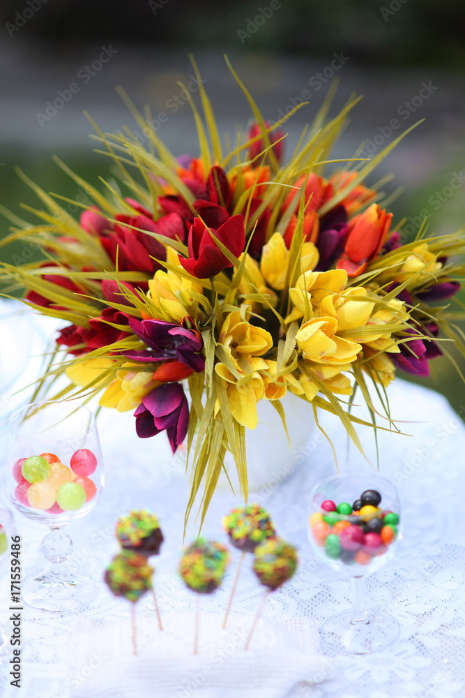 Obraz premium A festive table decorated with birthday cake with flowers and sweets. A table with a cake for the birthday of the child. Birthday party for children.