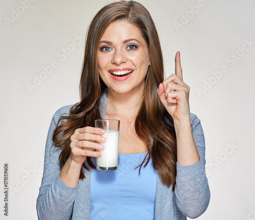 Woman holding milk glass pointing finger up.