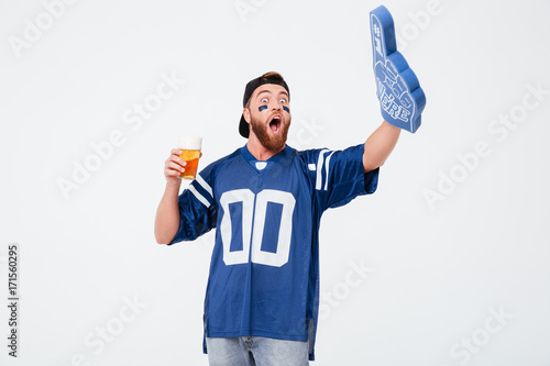 Emotional man fan in blue t-shirt drinking beer.