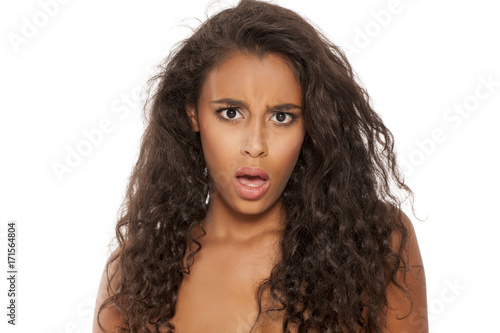 portrait of a shocked young dark-skinned woman on a white background