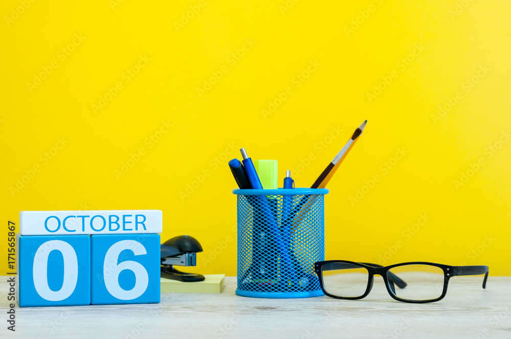 October 6th. Day 6 of month, wooden color calendar on teacher or student table, yellow background . Autumn time. Empty space for text October 6th. Day 6 of month, wooden color calendar on teacher or student table, yellow background . Autumn time. Empty space for text