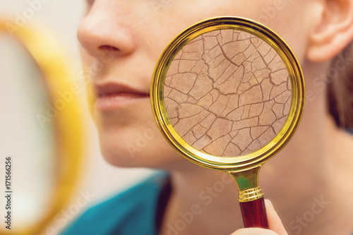 aging and dry face skin concept - woman with magnifying glass