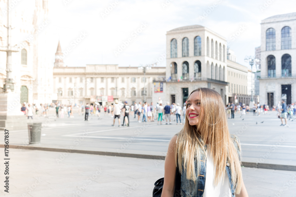 Pretty and smiling millennial teenager tourist visiting the city of Milan, in Italy