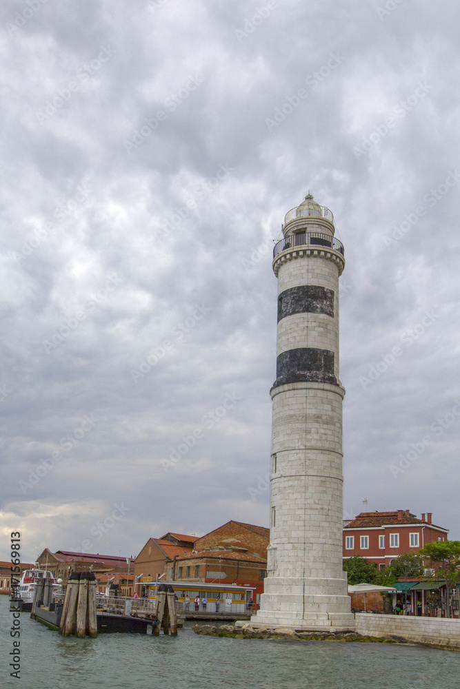 Old white lighthouse on the sea coastline.