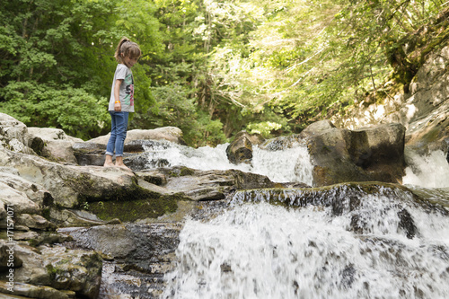 Girl next to the Waterfall of the bucket in the Selva de Irati in Navarra, Spain.
