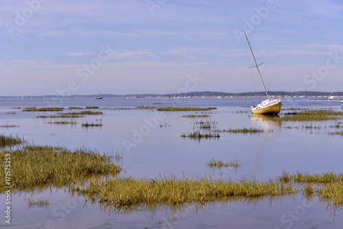 Sailboat at low tide at Arès, ostreicole commune located on shore of Arcachon Bay, in the Gironde department in southwestern France.