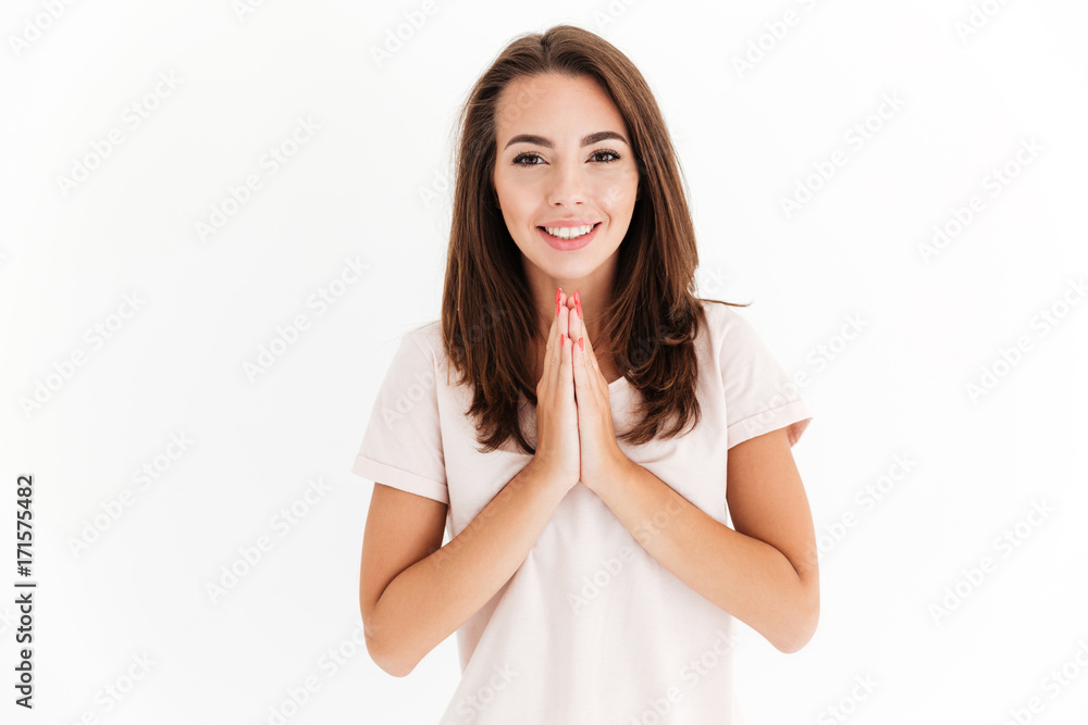 Smiling brunette woman holding hands in pray gesture Smiling brunette woman holding hands in pray gesture