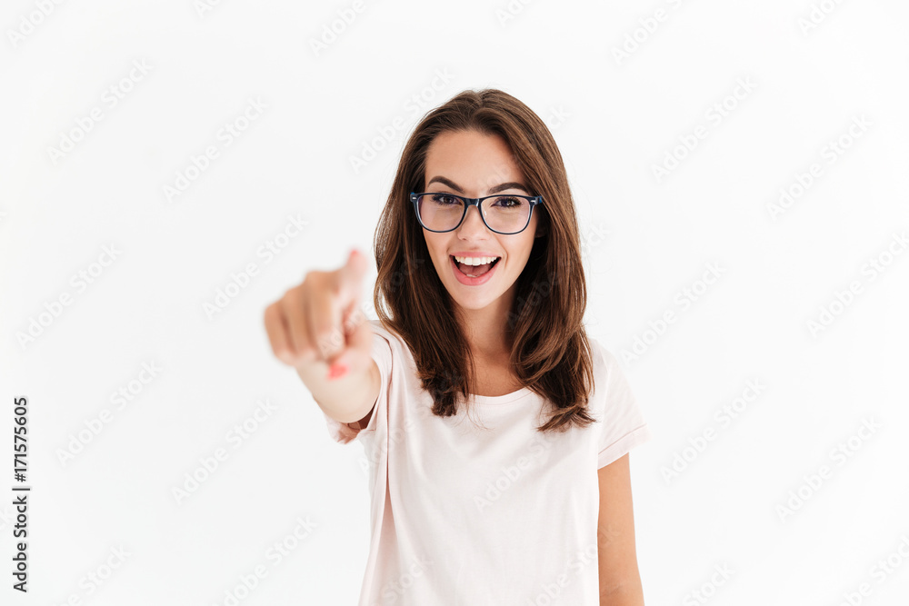 Happy brunette woman in eyeglasses pointing at the camera Happy brunette woman in eyeglasses pointing at the camera