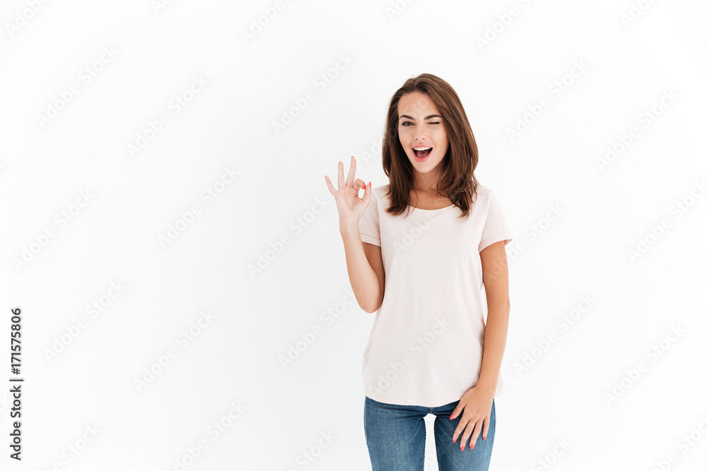 Attractive woman showing ok sign and winks at the camera Attractive woman showing ok sign and winks at the camera