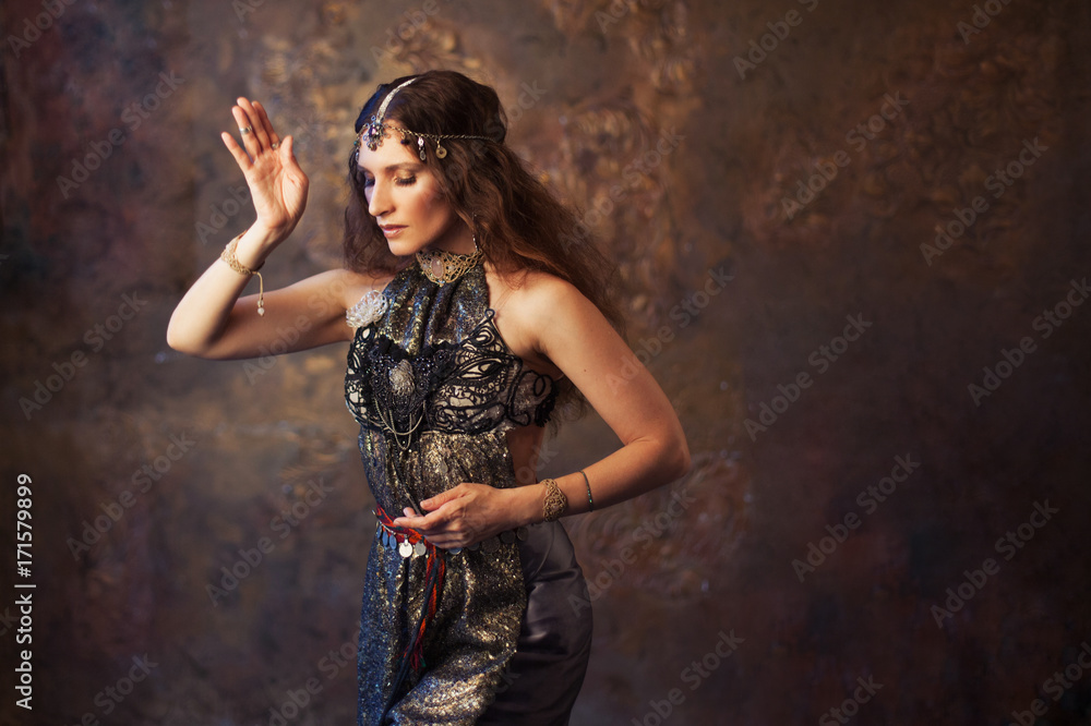Fototapeta premium Tribal dancer, beautiful woman in the ethnic style on a textured background
