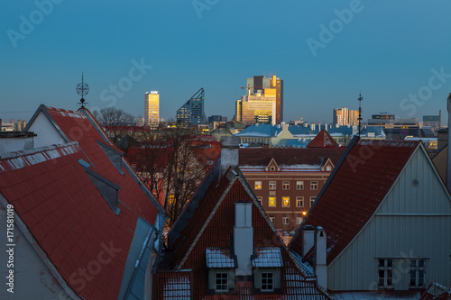 Exciting winter view of night old town of Tallinn. Aerial over roofs and towers.