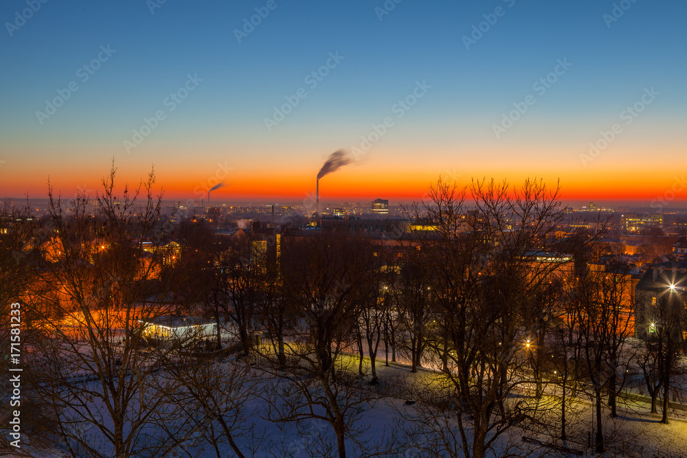 Obraz premium Exciting winter view of night old town of Tallinn. Aerial over park and industrial distrinct