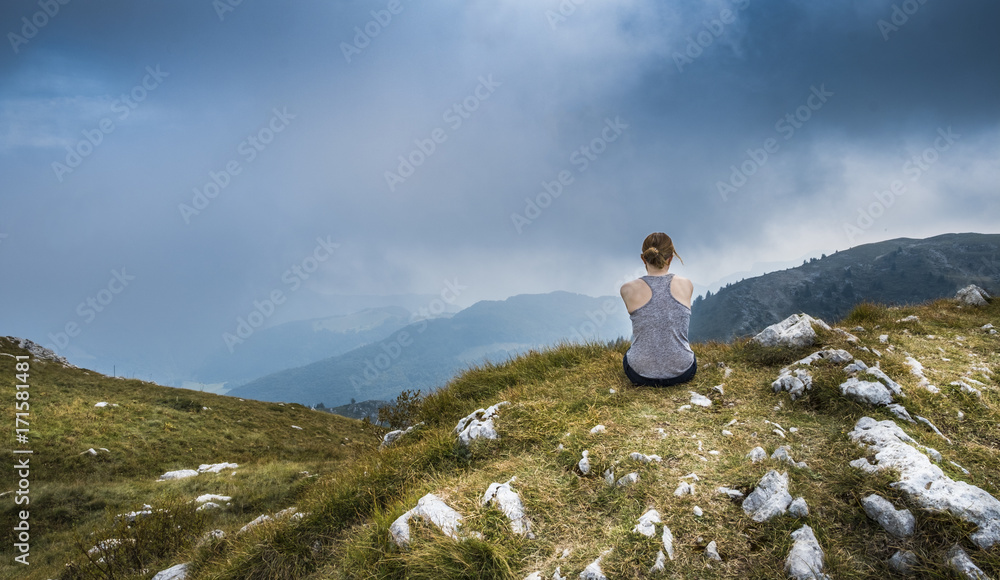 Yound Woman sitting on the top of a mountain