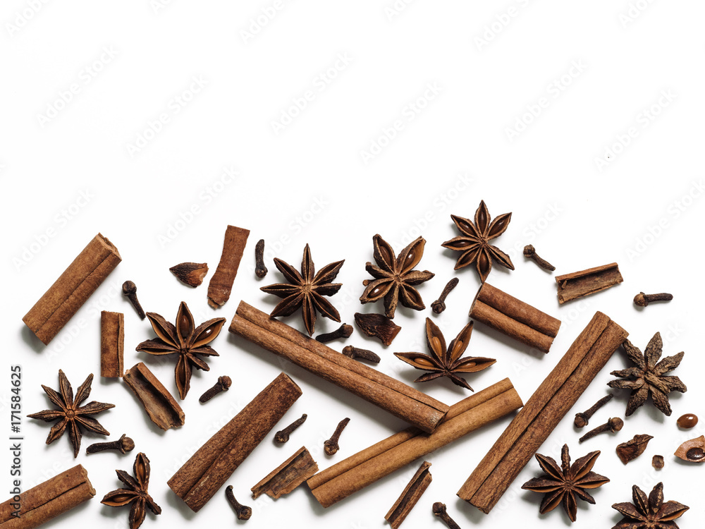 Winter spices background. Cinnamon, cloves and star anise with copy space. Isolated on white with clipping path. Top view or flat lay. Winter food background concept. Winter spices background. Cinnamon, cloves and star anise with copy space. Isolated on white with clipping path. Top view or flat lay. Winter food background concept.