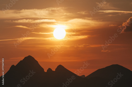 The sun sets over the mountain peaks