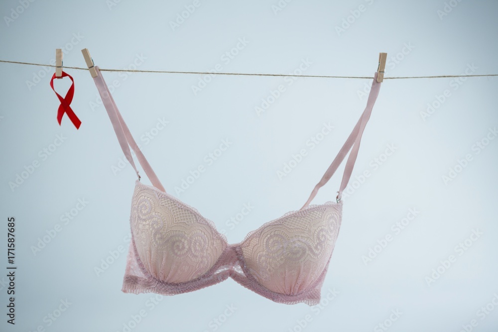 Red AIDS Awareness ribbon hanging by bra on string Red AIDS Awareness ribbon hanging by bra on string