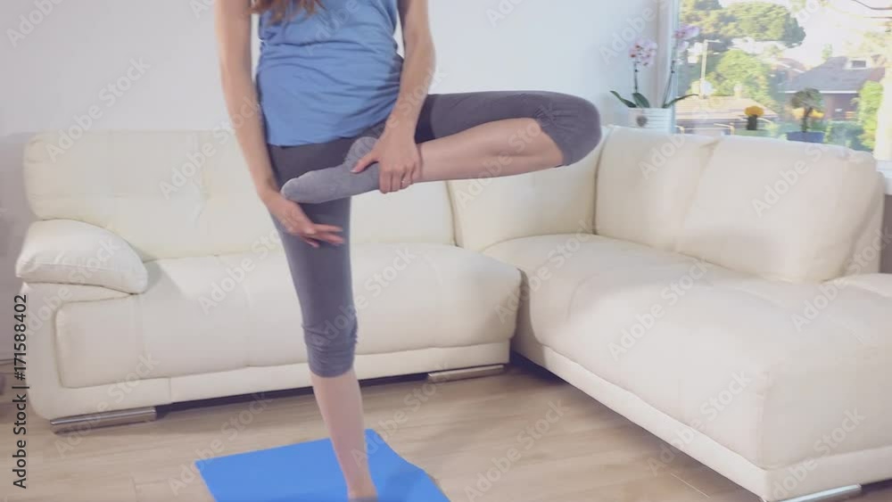 Woman doing yoga at home relaxing meditating dolly shot retro style